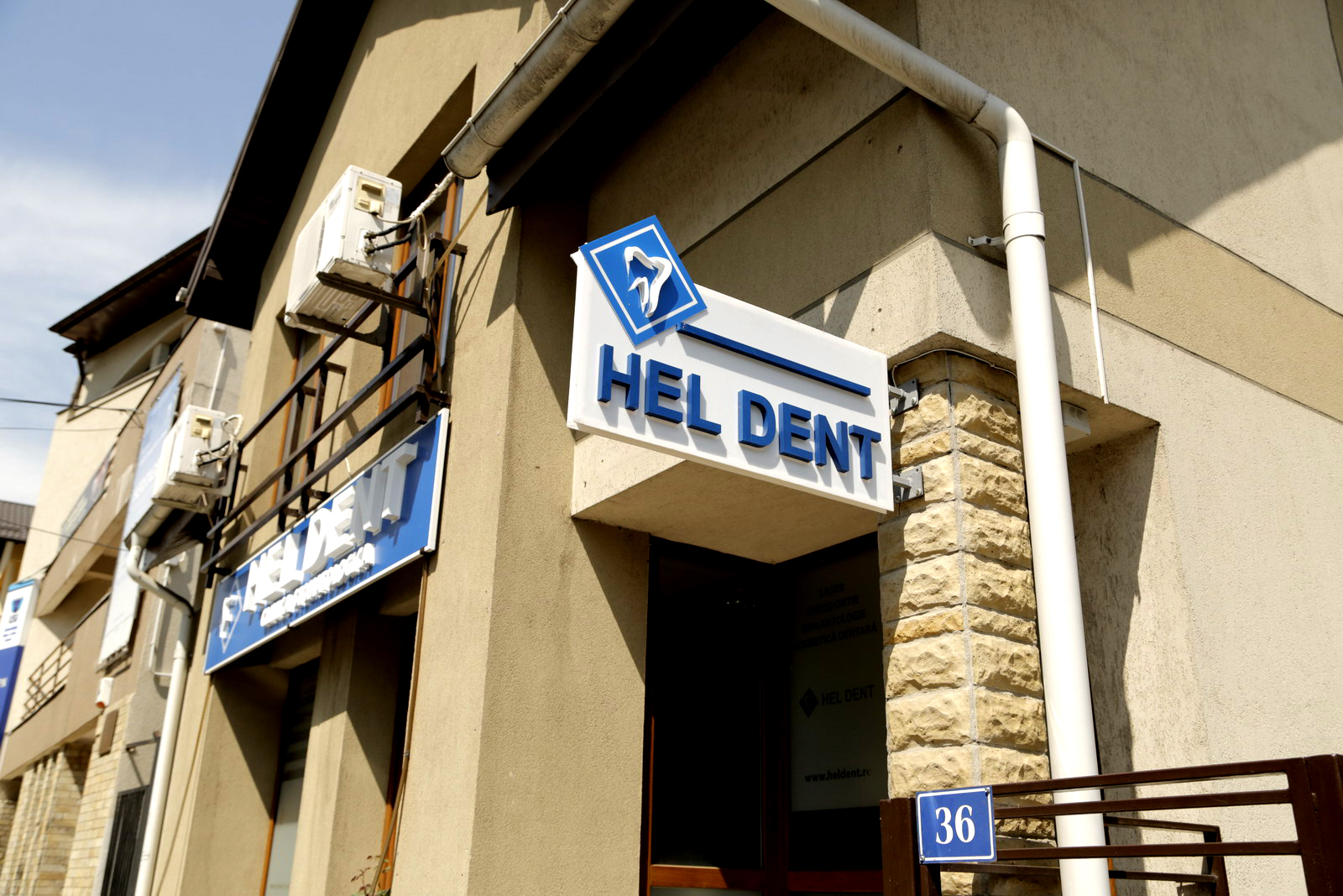Firma luminoasă HEL DENT de la intrarea în cabinet, la numărul 36